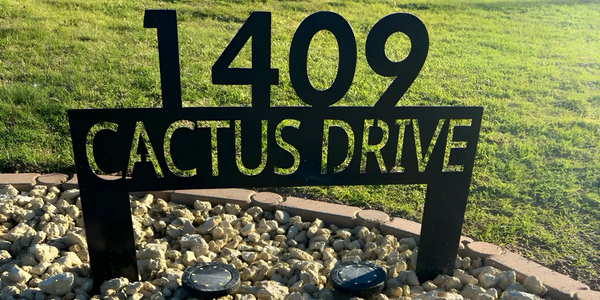 An example of metal sign customization featuring a street address and in-ground placement.