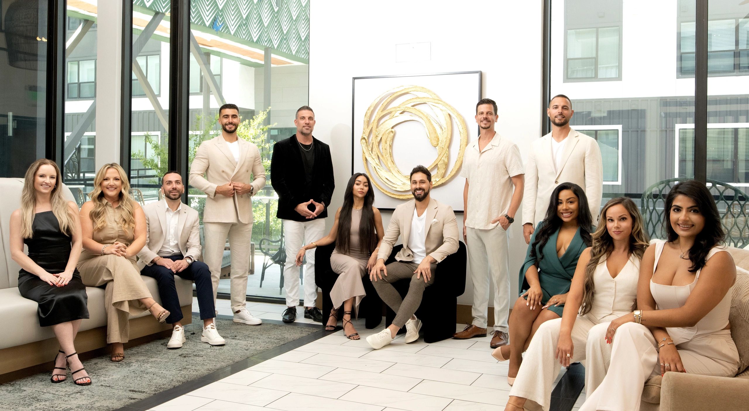 A diverse group of professionally dressed people posing in a modern office lobby.