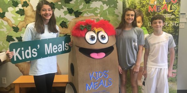 Three kids and a kids' meals box mascot.