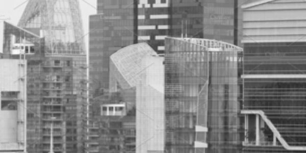 Black and white photo of modern glass skyscrapers in a city.