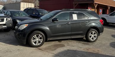 A dark gray SUV parked in a lot with other vehicles.