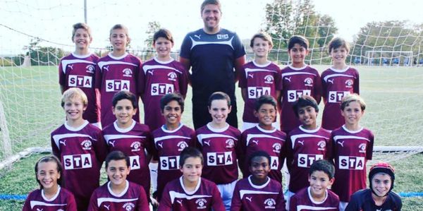 Youth soccer advisor John Tait coaching boys team training session focused on development.