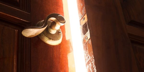 Door slightly open with bright light shining through, symbolizing clarity, purpose, fresh direction