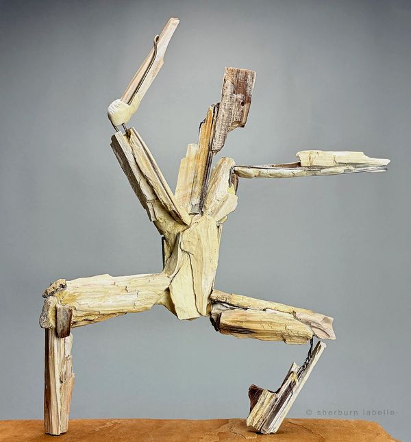 Abstract wooden sculpture resembling a dynamic dancing figure.