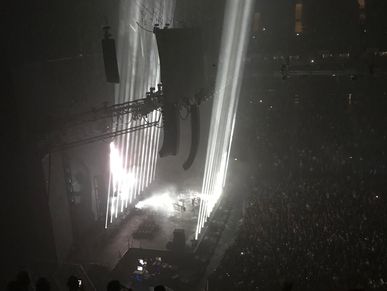 Concert stage with beams of light and audience.