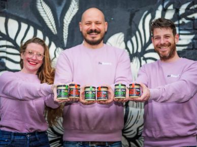 Three people proudly display jars of spreads.
