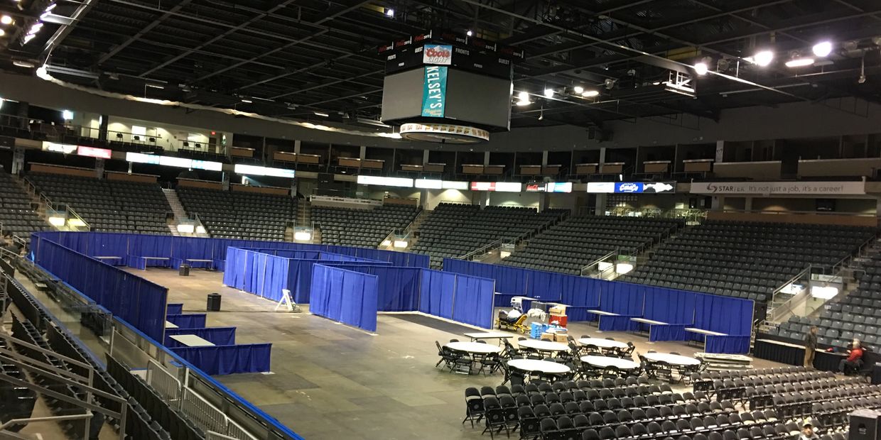 Empty arena with blue partition booths and chairs.
