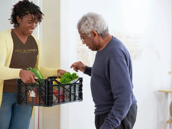 Home health aide preparing a meal for elderly client