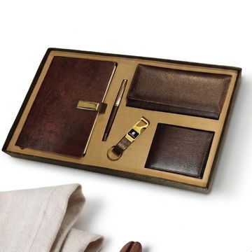 A brown leather gift set with notebook, pen, wallets, and keychain in a box.