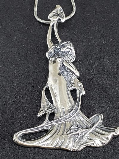 Silver angel pendant on black background