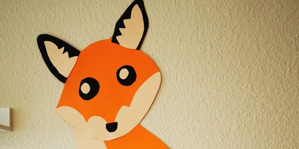 Eine handgemachte Fuchsdekoration aus Papier an der Wand.