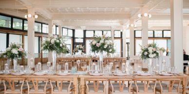 Elegant dining tables with floral centerpieces in a bright venue.
