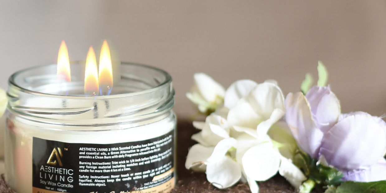 soy sandalwood candle with flowers on carpet