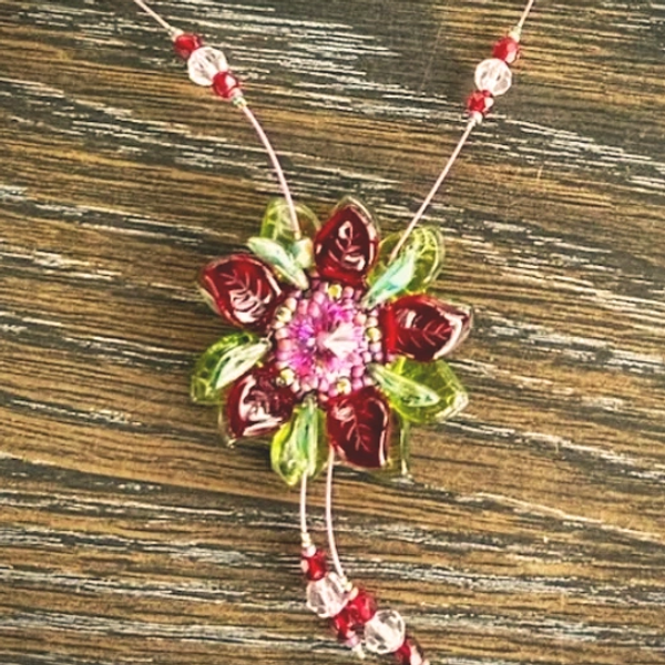a beaded pendant shaped like a pink 