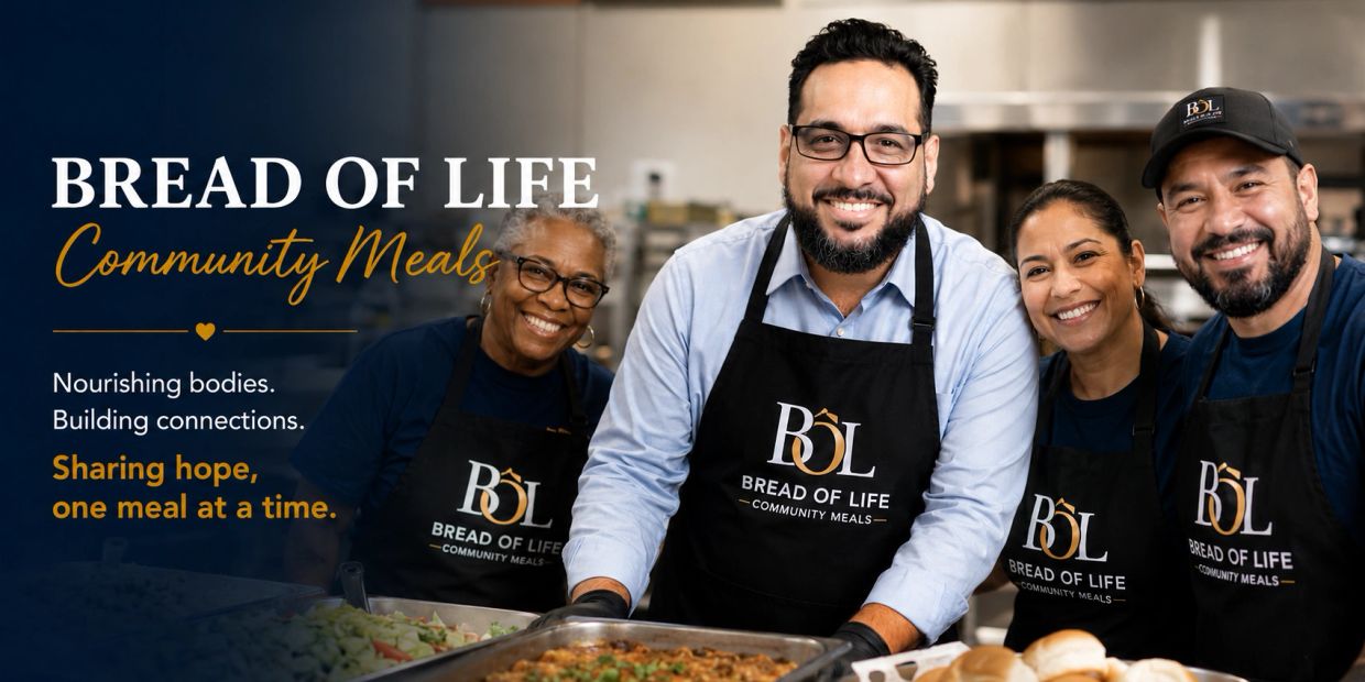 Smiling volunteers serving food for Bread of Life Community Meals.