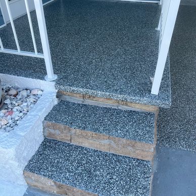 Escalones con revestimiento gris y barandal blanco.