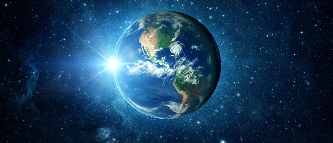 Earth illuminated by the sun in deep space with stars around.