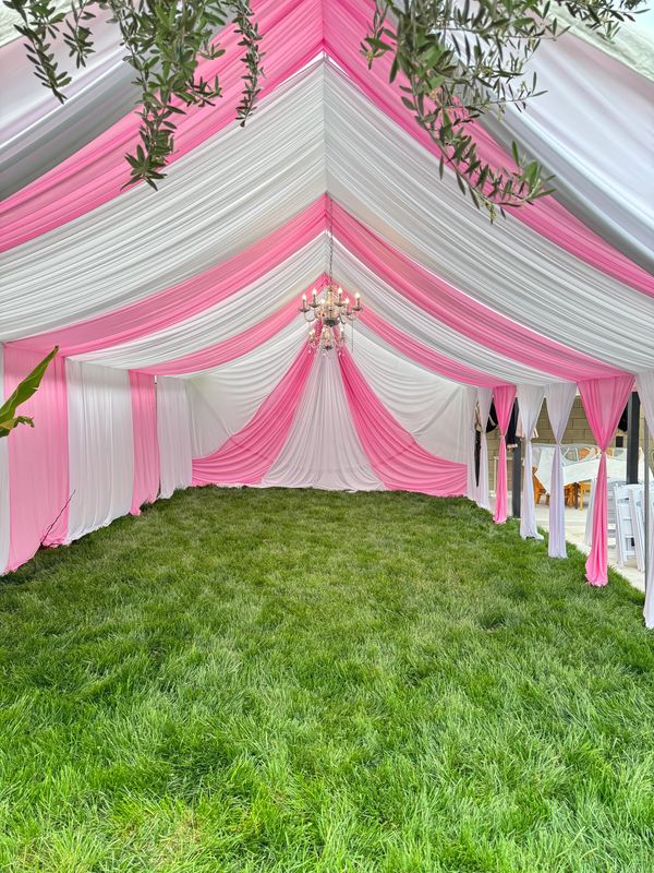 Pink and White tent with draping and chandeliers.