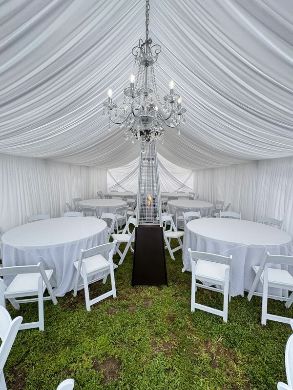 Tent Draping with round tables, white linens and white wedding chairs.