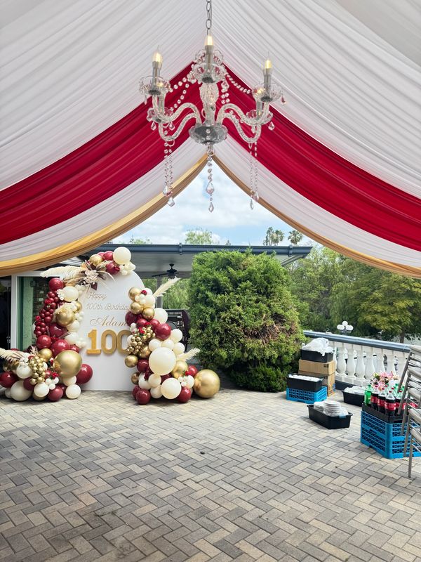  20x30 Canopy with Red and Gold Draping and Chandelier. 