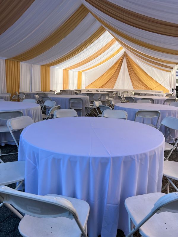 30x30 Party tent white and gold draping. White chairs and 5' round tables. Red Runners. Tablecloths.