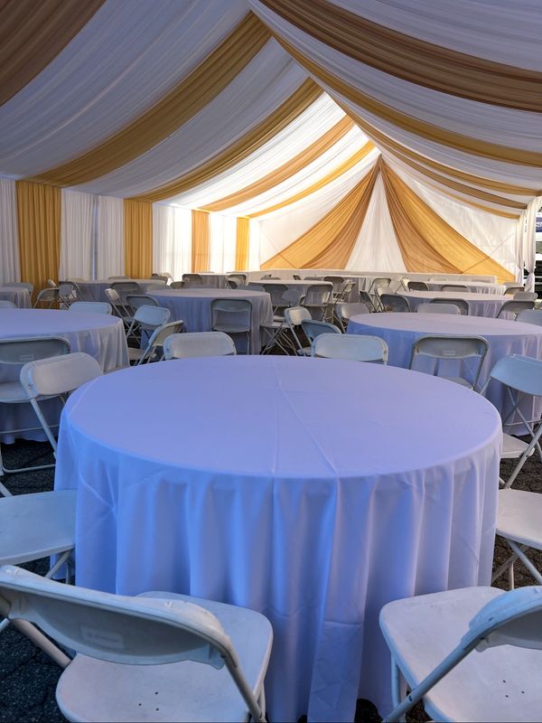 30x30 Party tent white and gold draping. White chairs and 5' round tables. Red Runners. Tablecloths.