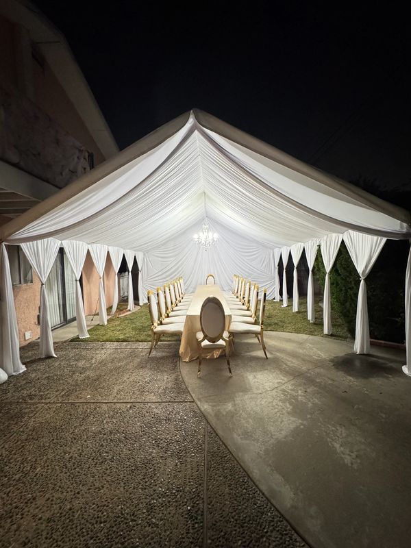 20x20 Tent with white draping fabrics and a chandelier. Fancy chairs provided by customer. Team work
