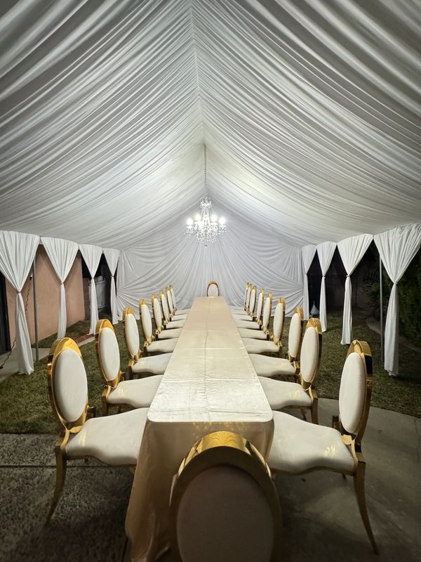 20x20 Tent with white draping fabrics and a chandelier. Fancy chairs provided by customer. Team work