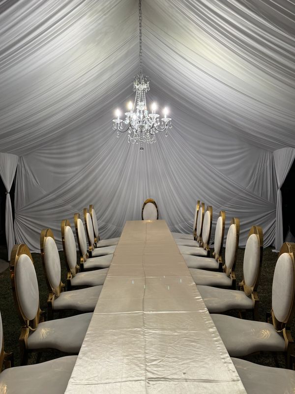 20x20 Tent with white draping fabrics and a chandelier. Fancy chairs provided by customer. Team work
