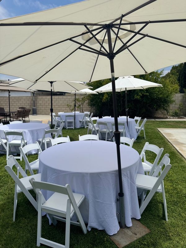9' Umbrellas color white for shade. White tablecloths with 5' round tables that seat 8-10 persons. 