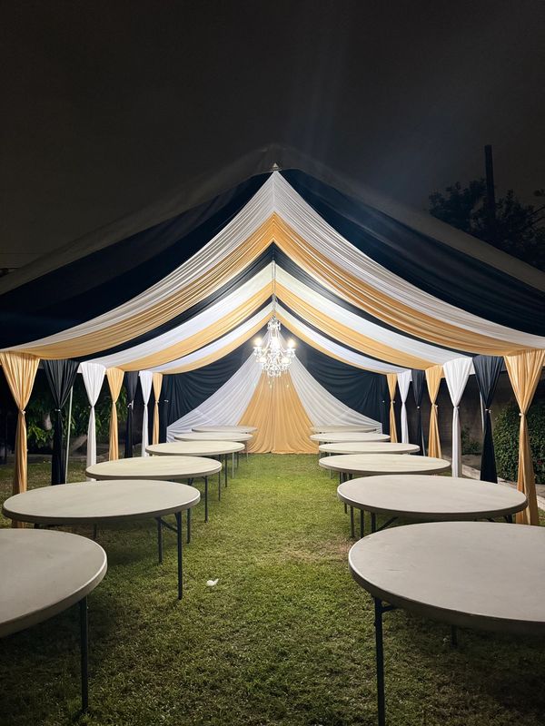 Party tent size 20x30 draped in black white and gold. Chandeliers included. 5' round tables.