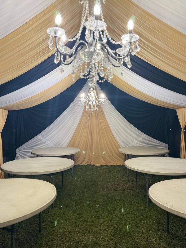 Party tent size 20x30 draped in black white and gold. Chandeliers included. 5' round tables.