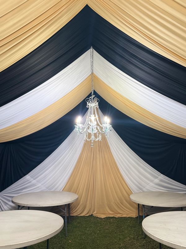 Party tent size 20x30 draped in black white and gold. Chandeliers included. 5' round tables.