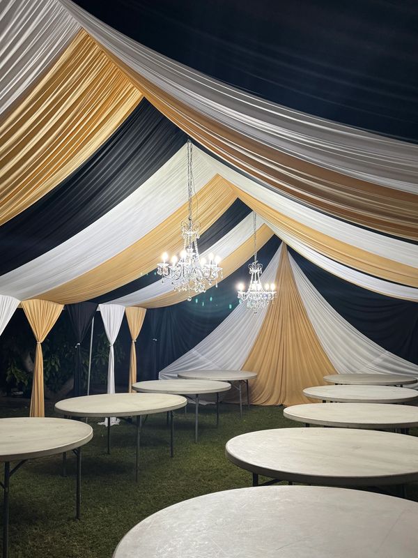 Party tent size 20x30 draped in black white and gold. Chandeliers included. 5' round tables.