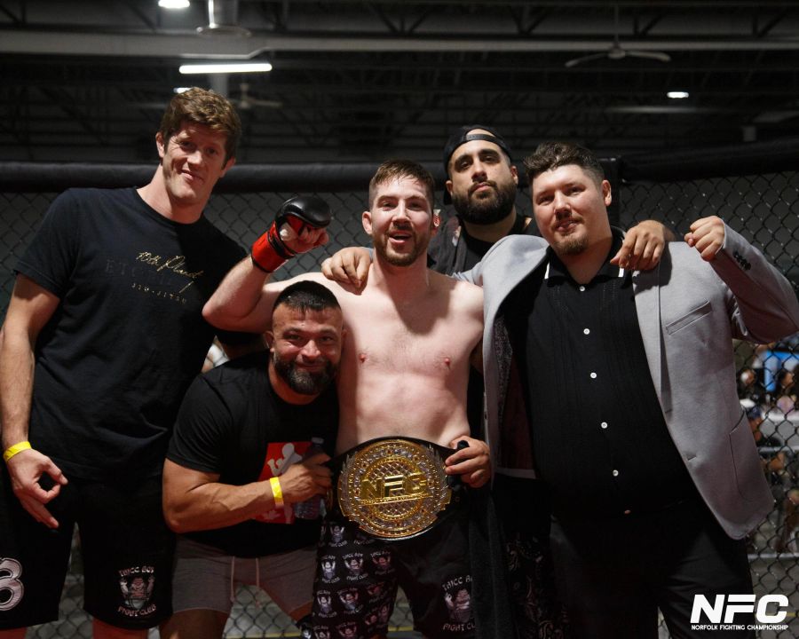 Team members with a championship belt