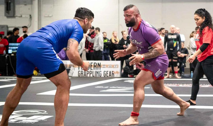 Two athletes grappling for control on the mats