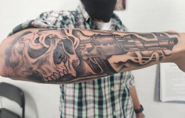 Black and grey skull and gun tattoos by Amber Tattoos Ajax ON
