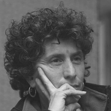 Black and white portrait of a thoughtful woman with curly hair.