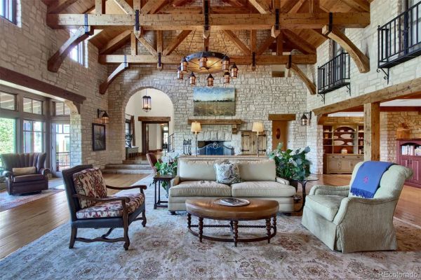 Rustic living room with wooden beams and stone walls.