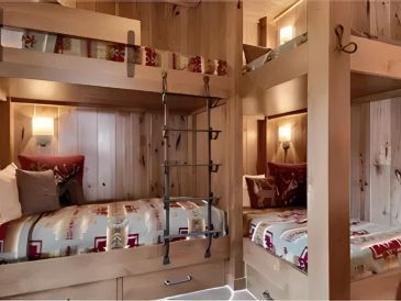 Cozy wooden bunk beds with patterned bedding.