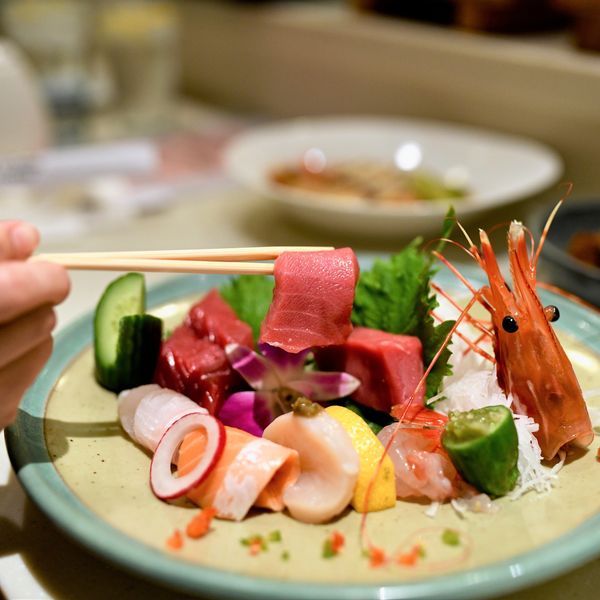Fresh sashimi assortment with tuna, shrimp, and cucumber on a plate.