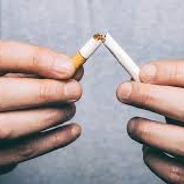 Hands breaking a cigarette in half to symbolize quitting smoking.