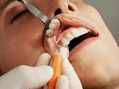 Close-up of dental check-up with tools inside a patient's mouth.
