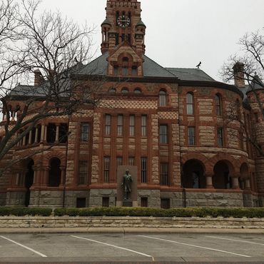 Historic red-brick courthouse with clock tower on an overcast day.
