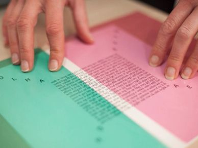 Hands interacting with a colorful paper featuring text and letters.