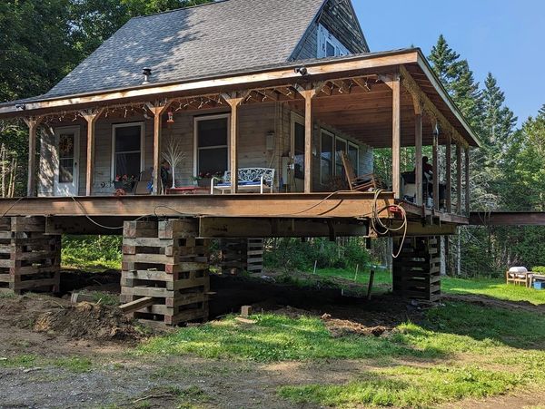 Elevated home with stacked timber cribbing  during a foundation replacement  by Swallow and Sons Exc