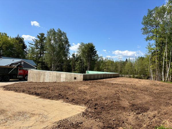 A completed concrete foundation with clean grading and soil prep surrounding the structure.
