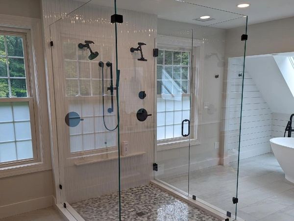 Modern bathroom with glass shower enclosure and freestanding tub.