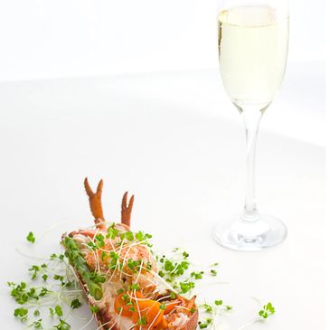 Lobster & micro herbs paired with a glass of sparkling wine or Champagne in a flute glass