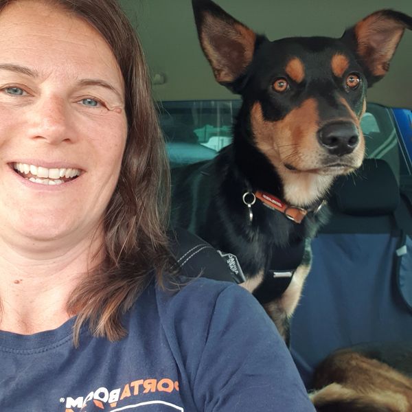 Woman smiling with her attentive dog in the car.